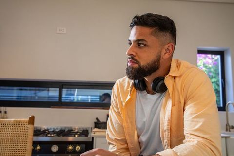 Contemplative man in modern kitchen with headphones