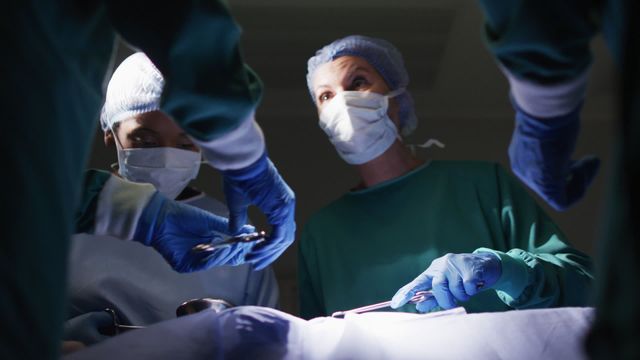 Healthcare professionals conducting surgery in a hospital operating room. Ideal for medical websites, health articles, hospital brochures, medical education materials, and healthcare-related advertising.