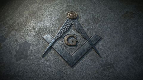 Freemasonry masonic emblem with square and compass on stone surface