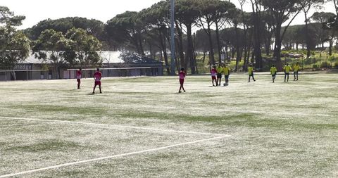 Youth soccer teams practicing teamwork on green field