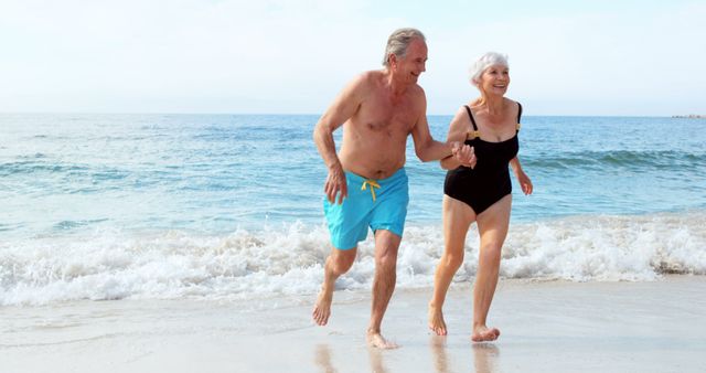 Senior couple enjoying a sunny day at the beach. Perfect for illustrating themes such as active lifestyle, retirement, vacation, leisure, togetherness, and happiness in elderly.