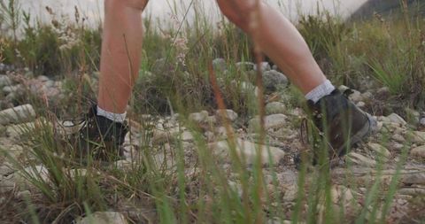 Hiker in Boots Navigating Rocky Terrain on Nature Trail