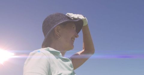 Senior Woman Playing Golf on Sunny Day with Lens Flare
