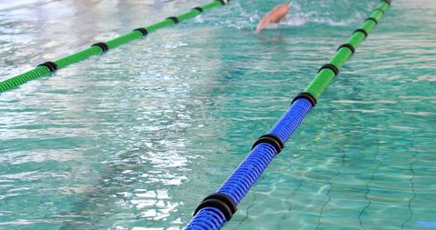 Swimmer Freestyle Racing in Indoor Pool Lane