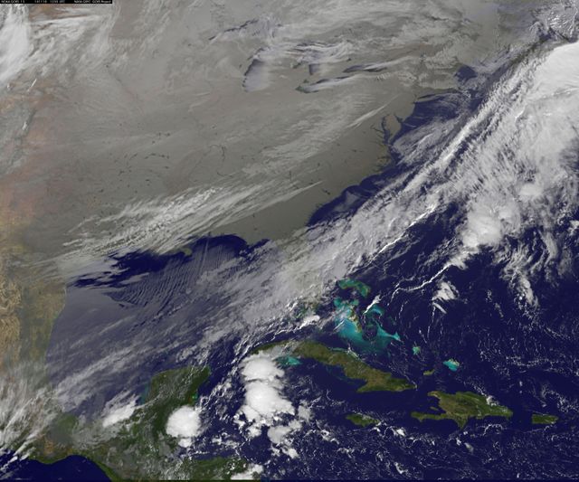 NOAA's GOES-East satellite provides a comprehensive view of icy-cold conditions spreading over the eastern two-thirds of the US and parts of the Atlantic Ocean on November 18, 2014. The image, taken in infrared to show temperature variations, highlights the cold clouds blanketing the region. This visual is highly useful for meteorological analysis, educational purposes, and illustrating severe winter weather patterns.