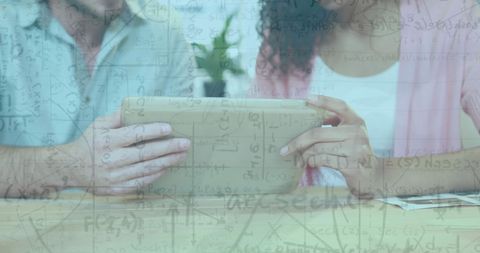 Team Collaborating on Tablet Overlaid with Mathematical Formulas