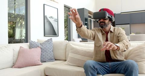 Man Engaging in Virtual Reality Game on Modern Couch