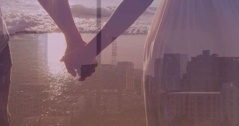 Couple holding hands at sunset overlapping coastal cityscape and golden hour romance