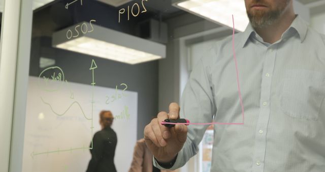 Businessman Drawing Graph on Glass Board during Meeting - Download Free Stock Images Pikwizard.com