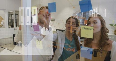 Team brainstorming on glass whiteboard with sticky notes in modern open-plan office