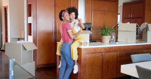 African american women embracing joyfully in kitchen during move