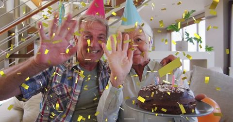 Joyful Senior Couple Celebrating Birthday with Cake and Confetti