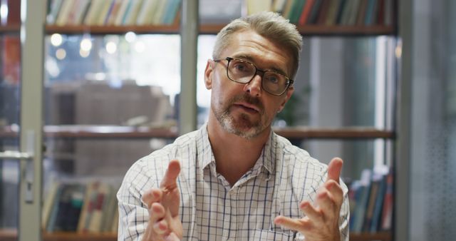 Mature Man Wearing Glasses Having Discussion in Library - Download Free Stock Images Pikwizard.com