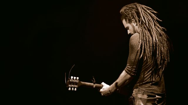 Man Playing Guitar with Dreadlocks on Stage in Dim Light - Download Free Stock Photos Pikwizard.com