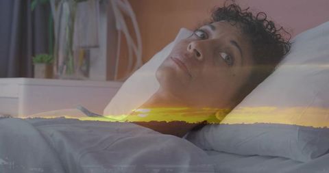 Reclining mature woman on bed with sunset double exposure evoking calm and reflection