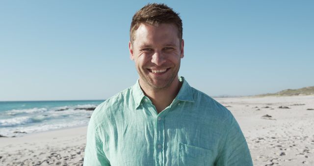 Man Smiling on Sunny Beach in Green Shirt - Download Free Stock Images Pikwizard.com