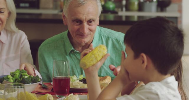 Grandfather Enjoying Meal with Grandson at Family Dinner Table - Download Free Stock Images Pikwizard.com