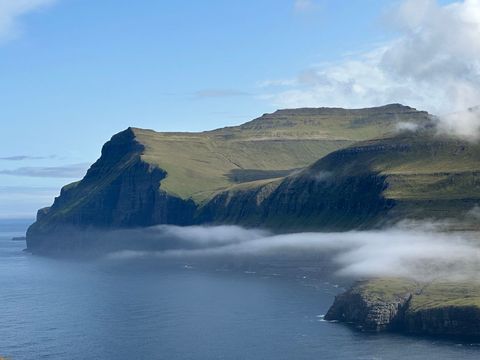Fog Rolling Along Rugged Sea Cliffs Featuring Grassy Plateaus and Ocean Horizon