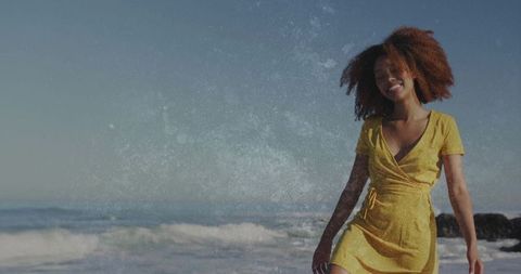 Carefree Woman Strolling on Beach in Yellow Dress with Blue Sky