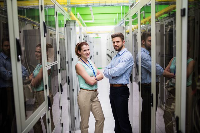 Portrait of technicians standing with arms crossed in a server room