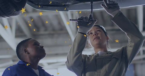 Mechanics Collaborating to Repair Vehicle in Auto Shop Garage