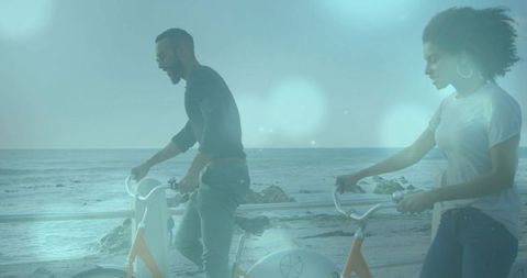 Couple Holding Handlebars on Coastal Promenade with Orange Bikes and Rocky Ocean Horizon