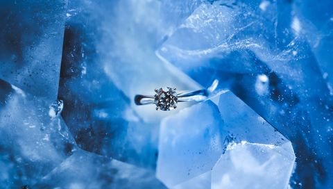 Elegant Solitaire Diamond Ring on Blue Crystal Surface