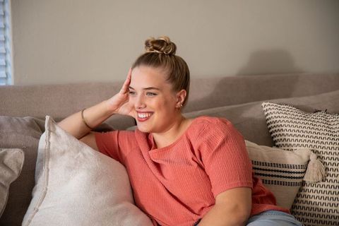 Joyful woman relaxing on sofa in cozy living room
