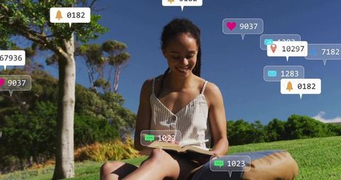 Young Woman Relaxing Outdoors with Book and Digital Notifications