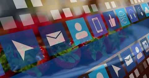 Translucent app icon grid overlaying blurred strawberries on blue plate for food tech