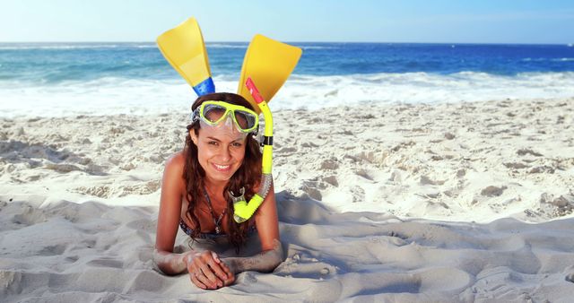 Smiling brunette with snorkeling equipment at the beach