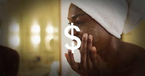 Black Woman Applying Skincare Cream in Illuminated Bathroom