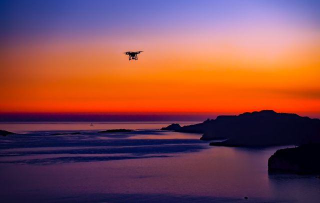 Perfect for use in technology, travel, and nature publications or advertisements. Can highlight modern photography techniques, the beauty of natural landscapes at dusk, and the tranquility of coastal settings. Suitable for promoting drone-related products or outdoor activities.