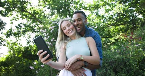 engaged couple taking selfie in lush garden - Download Free Stock Images Pikwizard.com