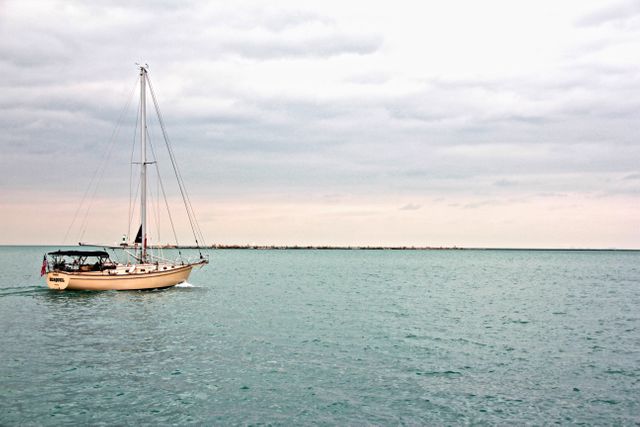 Sailing Boat on Calm Sea Under Overcast Sky - Download Free Stock Photos Pikwizard.com