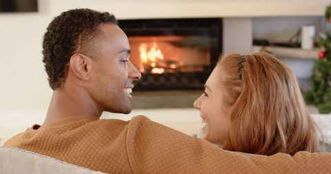 Happy Couple Relaxing by Fireplace in Cozy Living Room