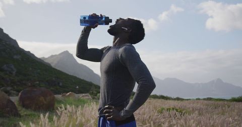 Man Hydrating During Hiking Adventure in Scenic Mountains