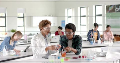 Students conducting chemistry experiment in modern science lab collaborating on tests