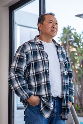 Senior man in plaid shirt relaxing on modern patio