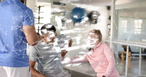 Therapist assisting seated client during rehab session in fitness studio with mirror