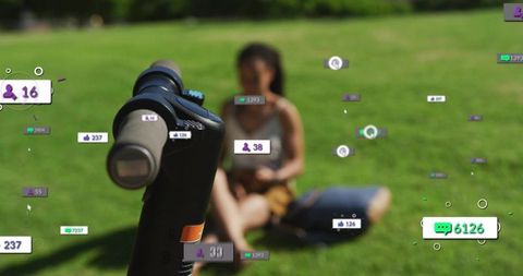 E-scooter handlebar with interactive augmented reality icons and seated woman on sunny park grass