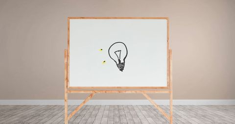 Minimalist light bulb sketch on wooden framed whiteboard in neutral room