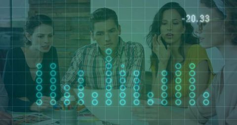 Creative team collaborating around laptop with holographic data visualization overlay