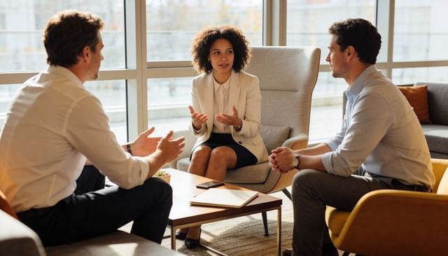 Female executive leading strategic team discussion in modern office lounge