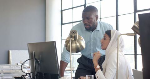 Diverse colleagues discussing project in modern office setting