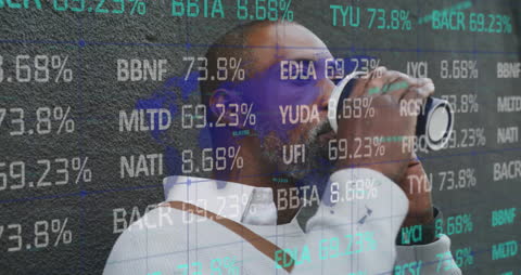 African American Man Analyzing Stock Market Data While on Phone