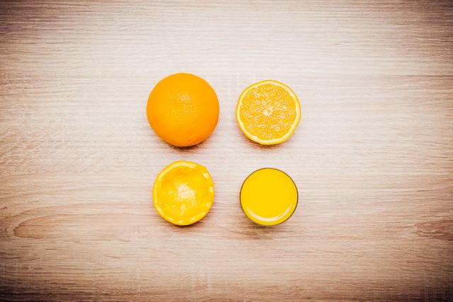 Orange progression on wooden table with whole orange, halved orange, freshly squeezed orange juice, nutrition. Perfect for health blogs, recipes, food-related articles, wellness campaigns, juice promotions.