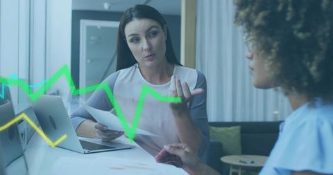 Businesswoman Discussing Analytics with Colleague, Laptop Reports and Green Trend Lines