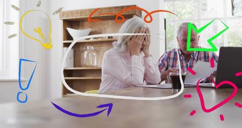 Elderly couple reviewing finances in kitchen