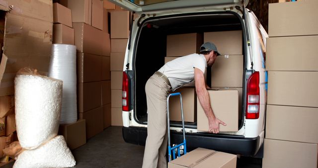 Delivery driver packing his van in a large warehouse - Download Free Stock Photos Pikwizard.com